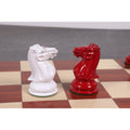 Side-by-side close-up of handcrafted white and red Staunton chess knights.