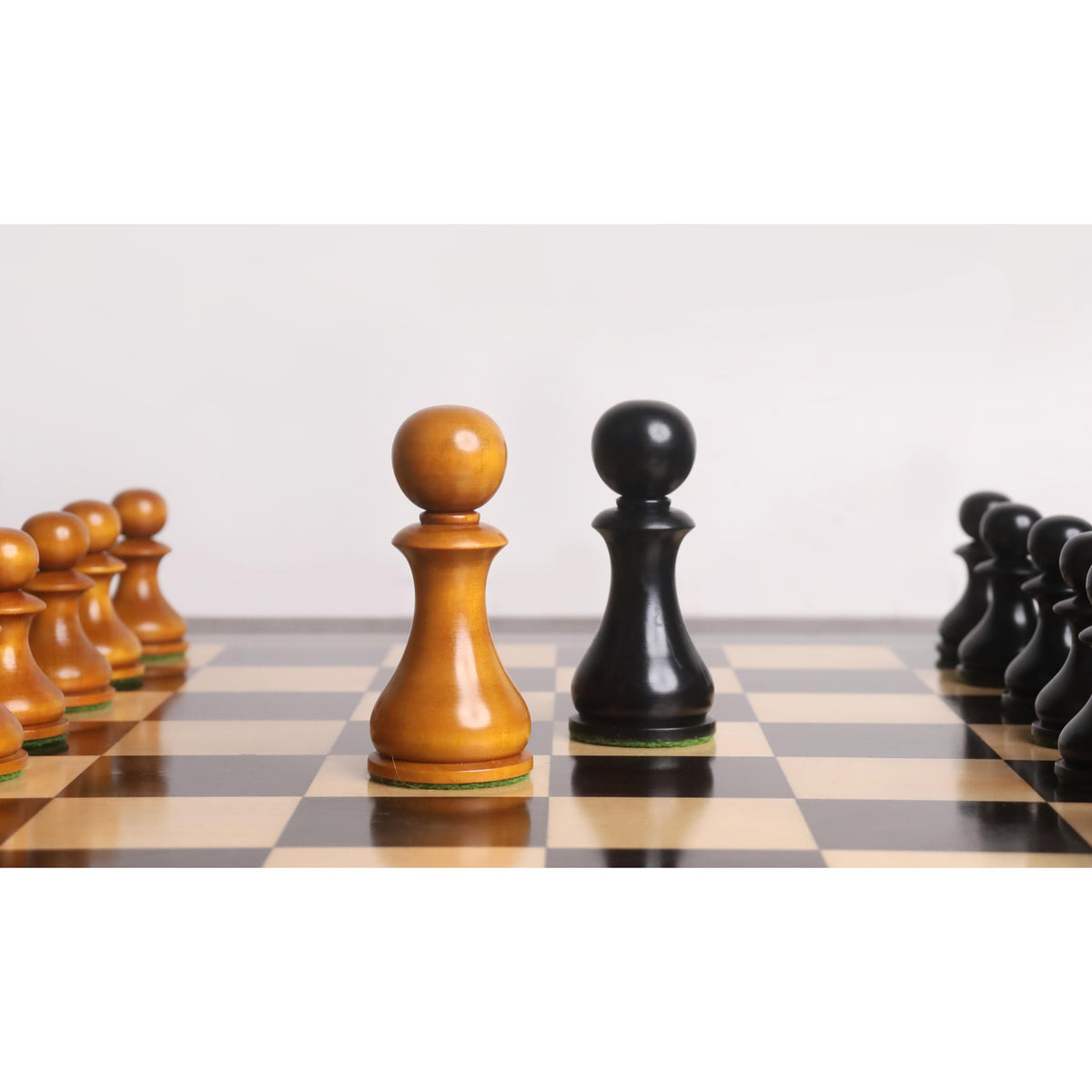 Antiqued and Ebonised English Dublin pawns face off in the center of a chessboard.