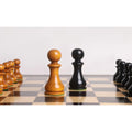 Close-up of black and Antiqued Boxwood English Dublin pawns on a wooden chess board.