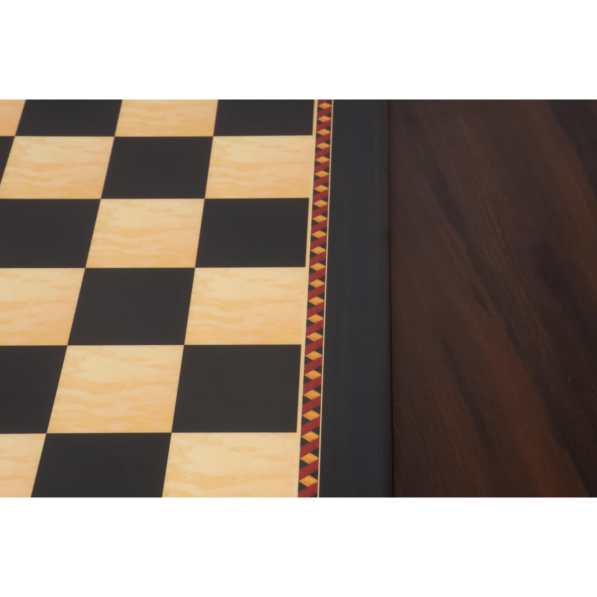 Close-up of the border transition between the ebony edge and the printed playing surface of the chess board.