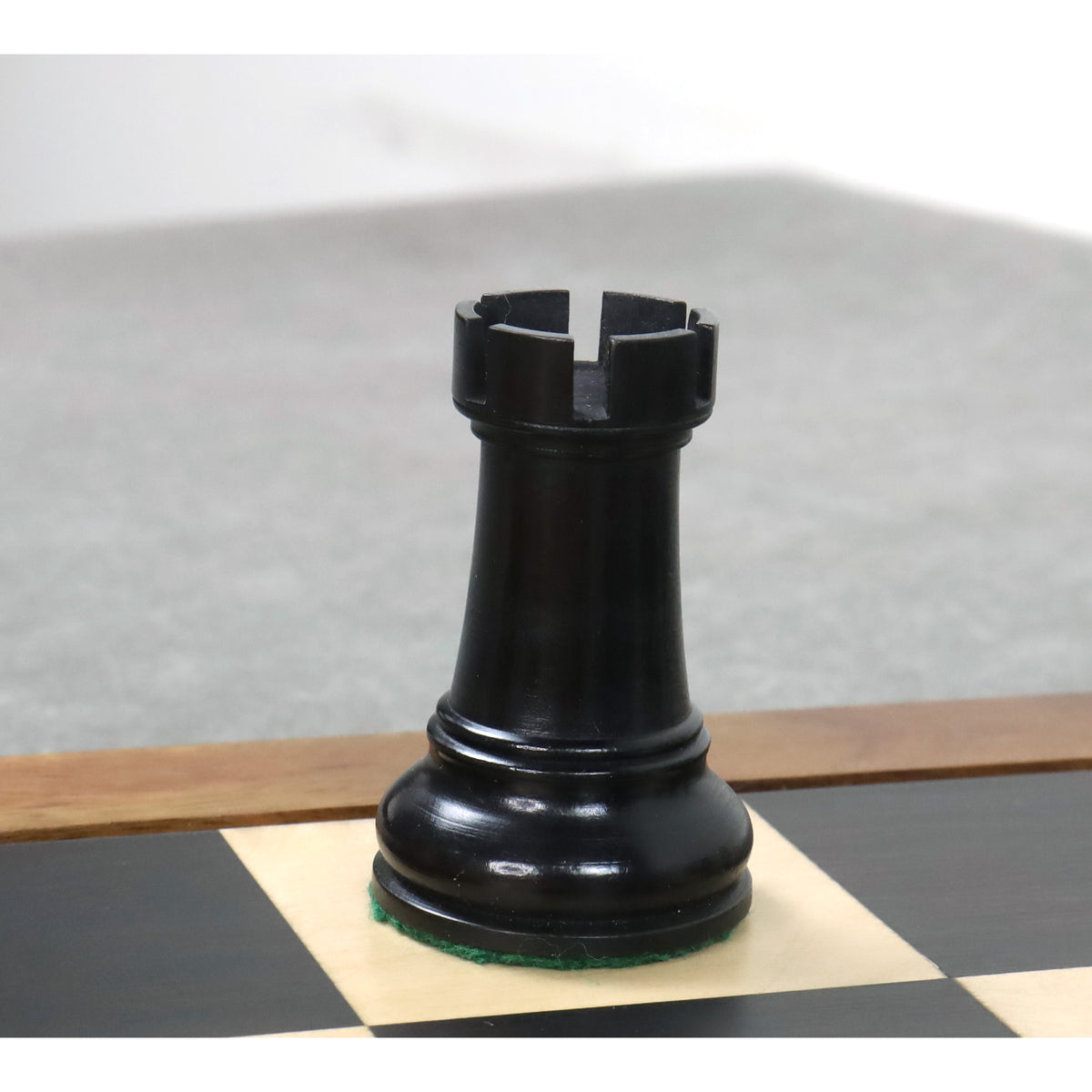 A single black ebonised boxwood rook piece from the 4-inch Leningrad Staunton chess set.