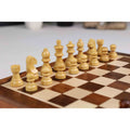 Light wooden magnetic chess pieces set up for play on a travel-sized rosewood board.