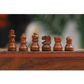Detailed side view of dark side golden rosewood chess pieces.