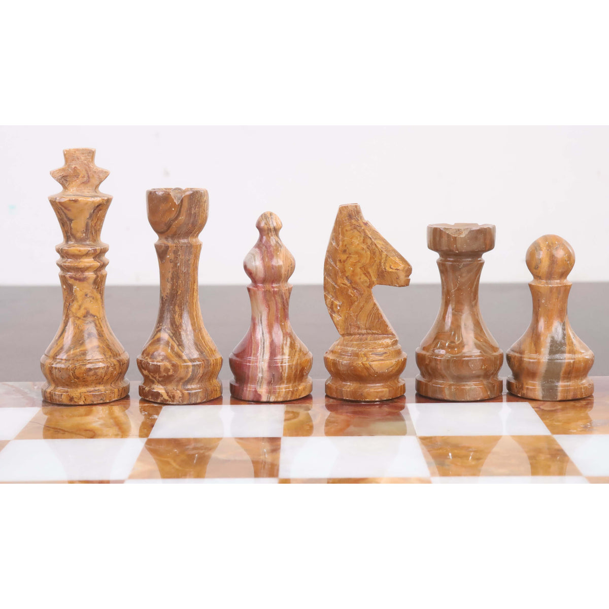 Row of brown onyx stone chess pieces including the king, queen, bishop, knight, rook, and pawn.