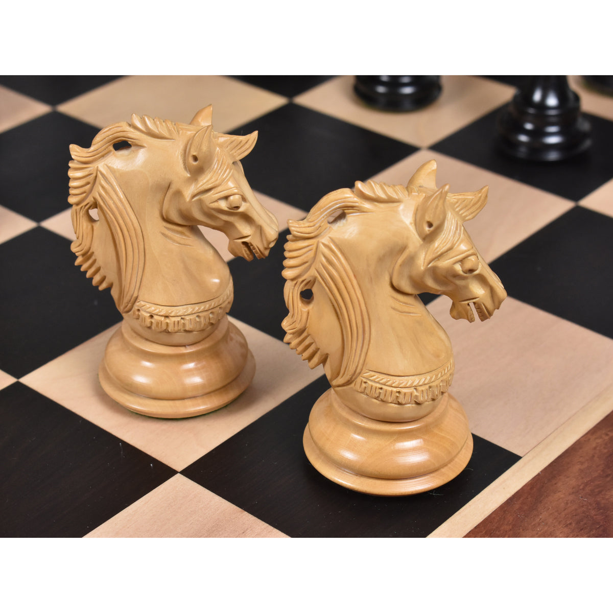 Two intricately carved boxwood knight chess pieces from the Prestige Luxury Staunton set.