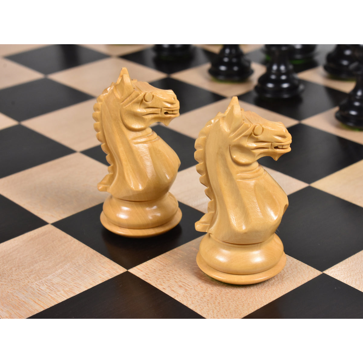 Close-up of two intricately carved Fierce Knight Staunton Ebonized Boxwood Knights on a chessboard.