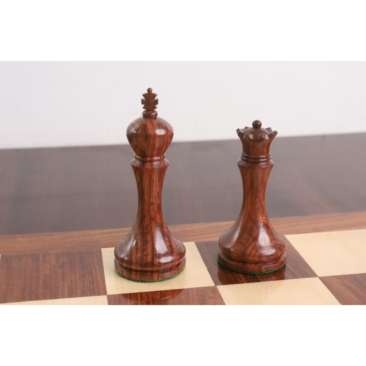 Golden rosewood king and queen pieces displaying elegant modern design.