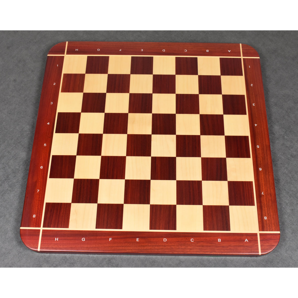 Full top-down view of the 23" tournament-size Bud Rosewood and Maple chessboard on a dark textured surface.