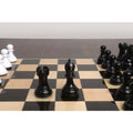 Black Pro Staunton rook and bishop pieces standing on the polished surface of an ebony wooden chess board.