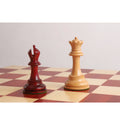 Bud rosewood bishop and boxwood queen chess pieces on a wooden board.