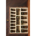 Dark Staunton chess pieces stored in the velvet-lined drawer of a golden rosewood board.