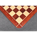 High-angle corner shot of the algebraic notations on a red Bud Rosewood border against a dark grey background.