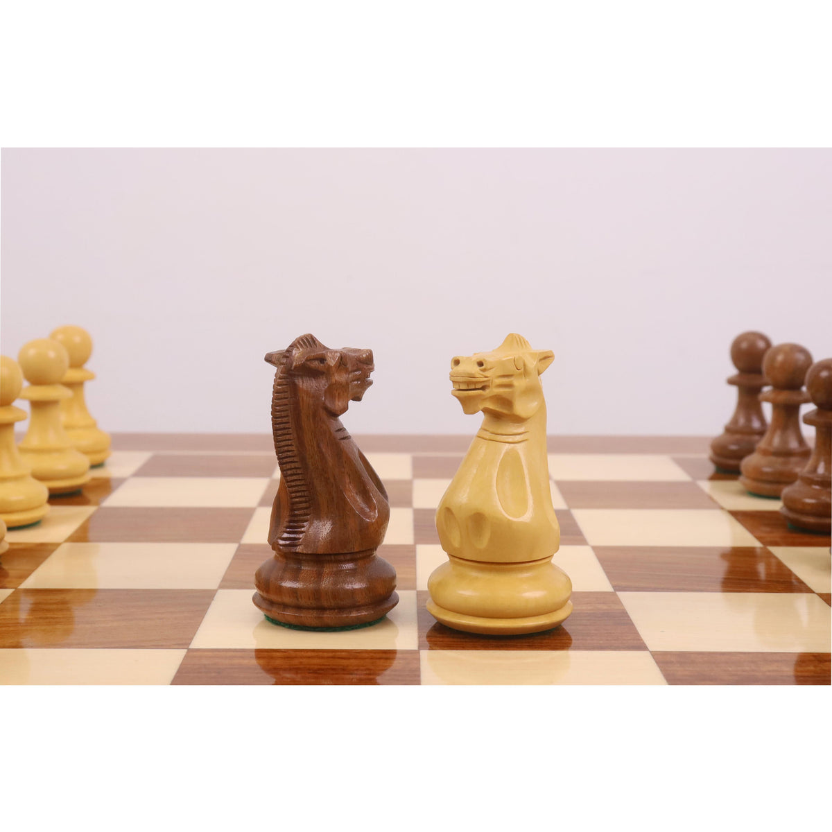 Close-up of the 4.1" King and Queen Pro Staunton weighted pieces in Golden Rosewood on a glossy chess board.