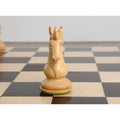 Hand-carved Goliath Series white Knight chess piece displayed on a wooden board.