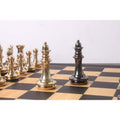 Metallic gold and grey queen chess pieces in a face-off on a classic wooden chessboard.