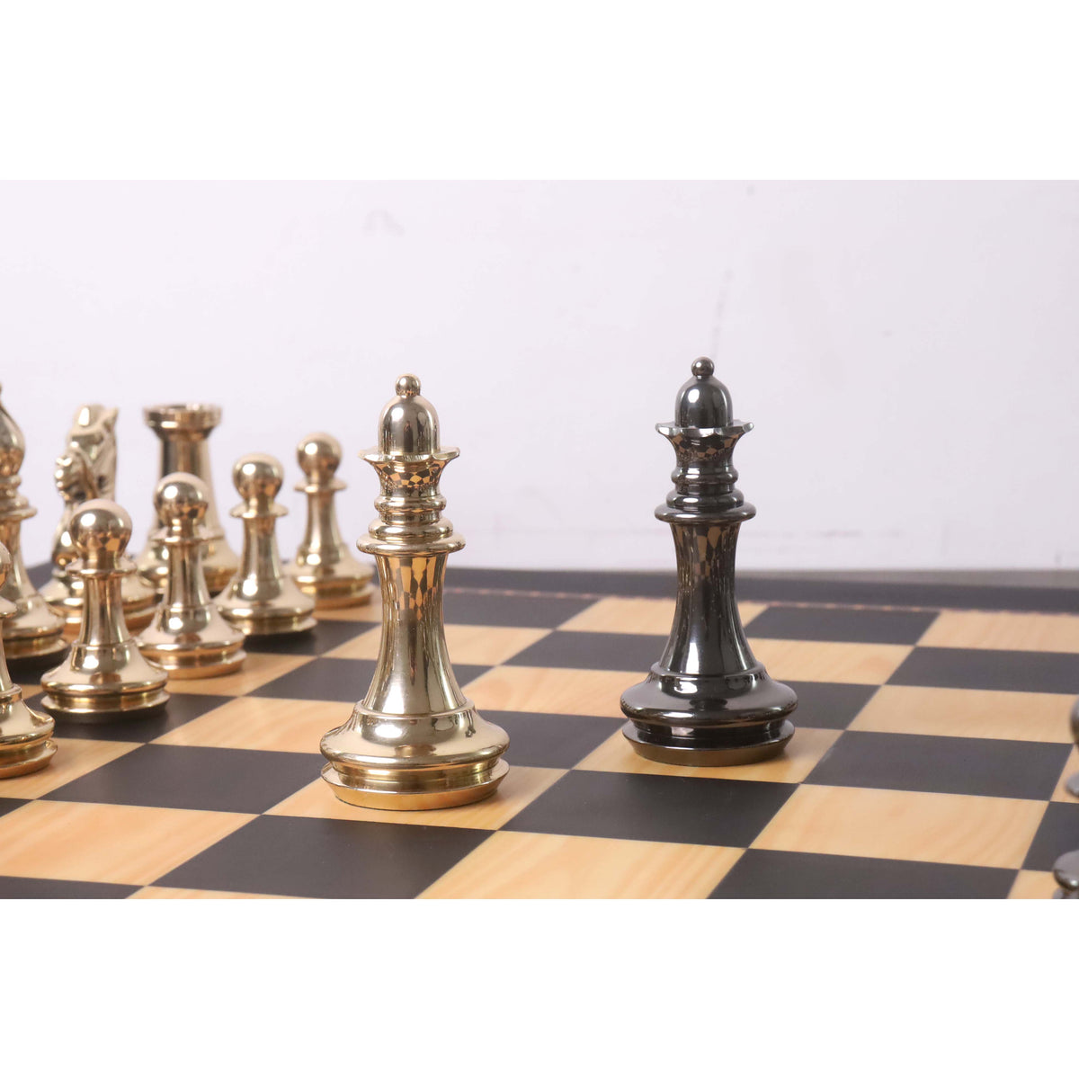 Metallic gold and grey queen chess pieces in a face-off on a classic wooden chessboard.