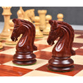 Close-up of intricately carved bud rosewood knight pieces on a wooden chess board.