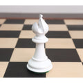 Close-up of a white texture painted Staunton Bishop chess piece standing alone on a wooden chessboard.