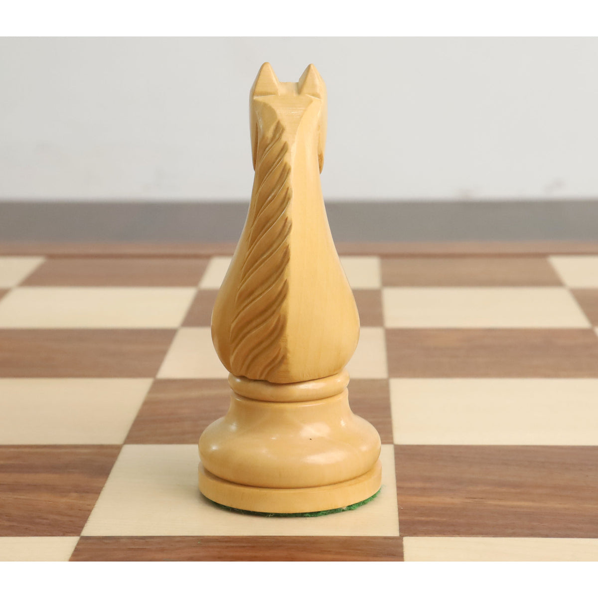 Rear view of a hand-carved wooden chess knight showing detailed mane