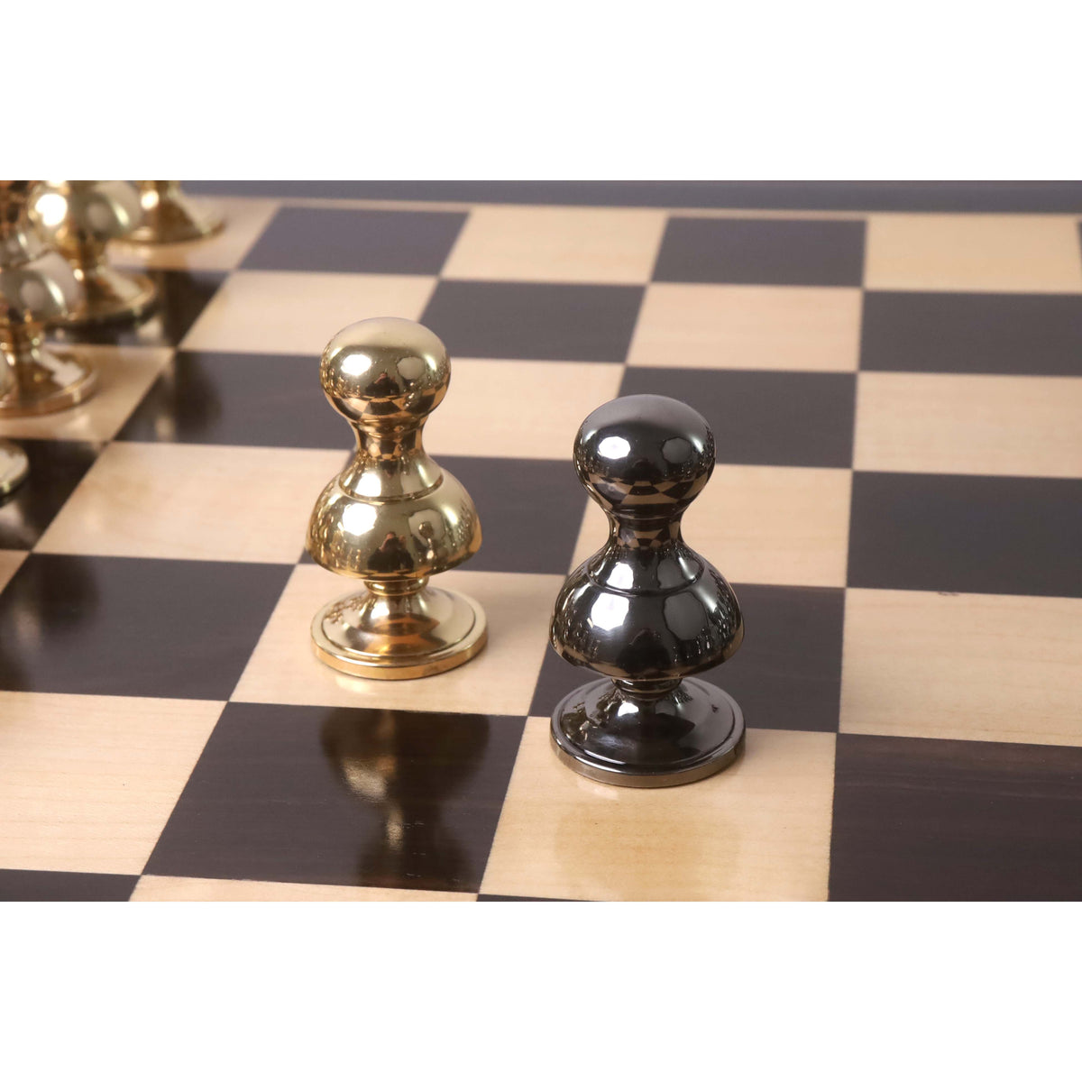 Gold and grey Victorian metal pawns positioned together on a chessboard.