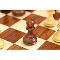 Macro shot of a single dark Golden Rosewood pawn on a polished wooden chess board.