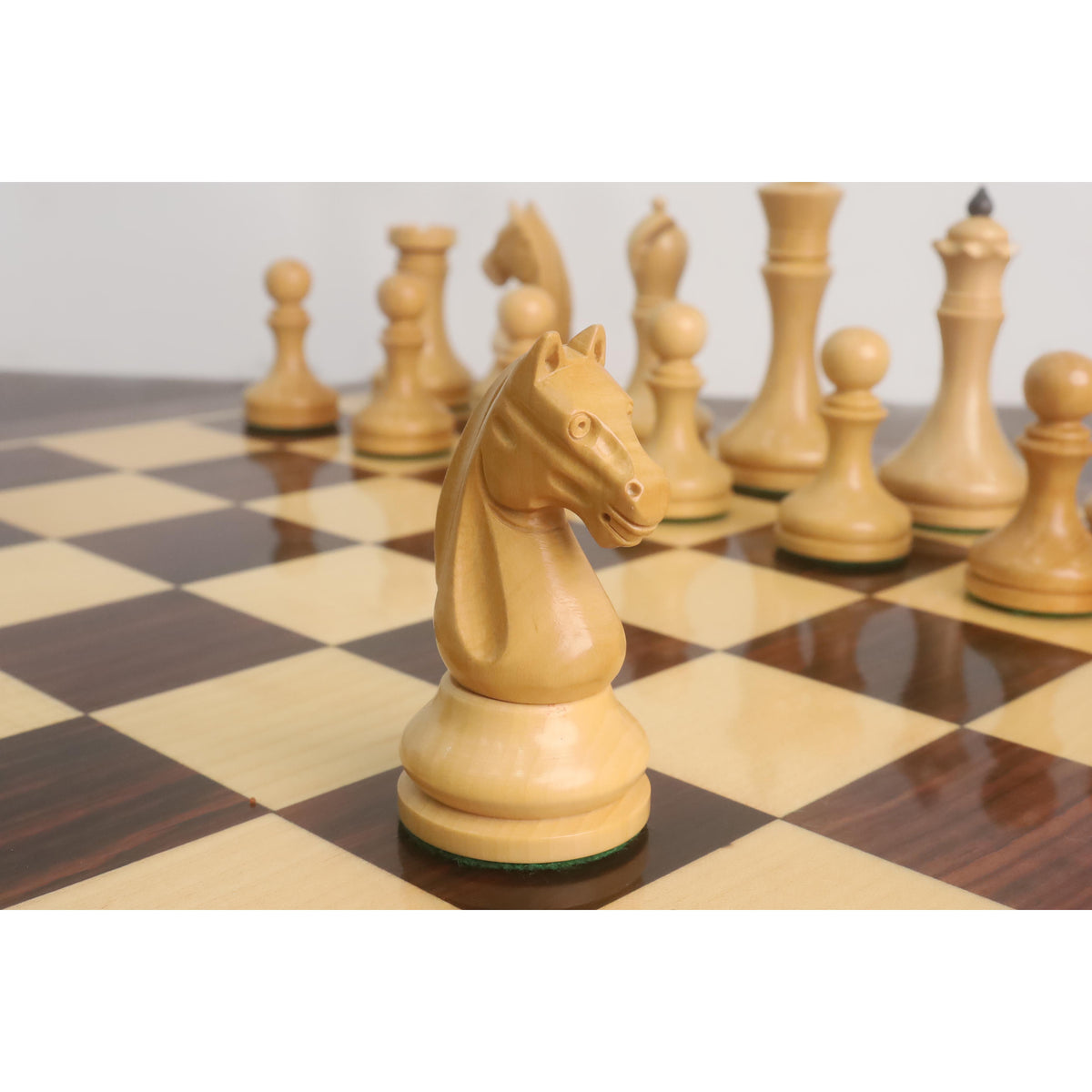 Natural boxwood Knight of the 3.8" Candidates Series Minimalist chess set facing right on a chessboard.