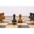 Black and antiqued boxwood Pawn chess pieces from the Golden Castle reproduction set on a wooden board.