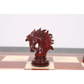 Detailed profile of a handcrafted crimson stained Knight chess piece on a glossy chessboard.