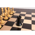 Hand-carved ebony wood Rook with a red crown stamp on a premium checkered wooden chessboard.