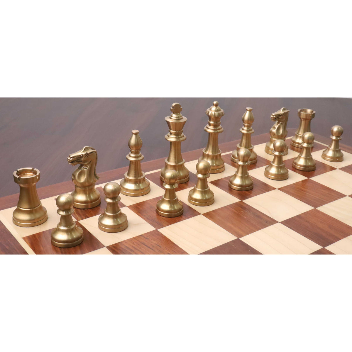 Complete lineup of matte gold pieces from the Pro Staunton brass metal luxury chess set arranged on a wooden board.
