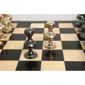 Two individual Victorian series brass metal chess set pawn pieces positioned diagonally on the board.