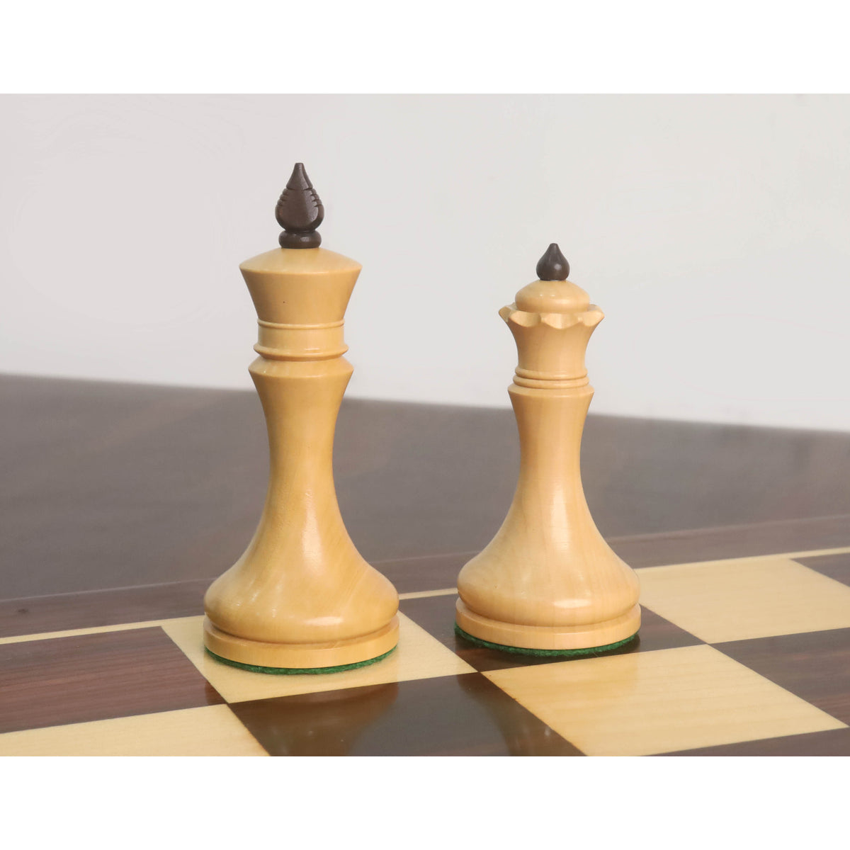 Natural boxwood King and Queen of the 3.8" Candidates Series Minimalist chess set standing on a chessboard.