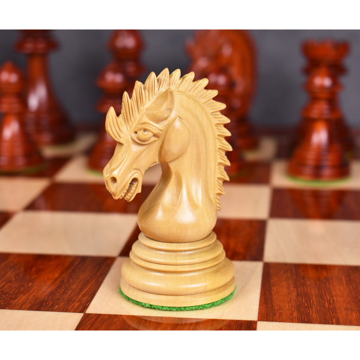 A close-up of the detailed light Bud Rosewood Dragon Knight on a wooden chessboard, facing left.
