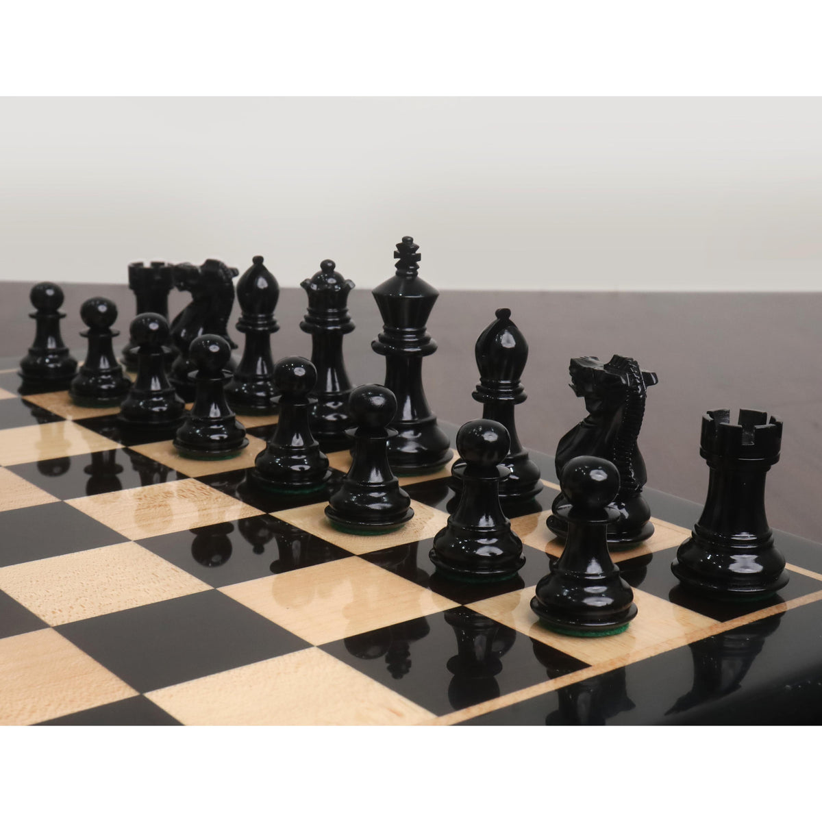 Complete side of black Pro Staunton 3 inch chess pieces ready for play on a board.