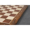 Side view of the algebraic letters A through H engraved on the Golden Rosewood border of a 21-inch chessboard.