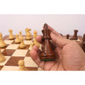 Hand holding a handcrafted 3.6 inch Golden Rosewood King from the Monarch Series set.