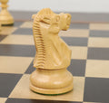 Handcrafted natural boxwood knight from the Reykjavik series standing on a wooden chessboard.