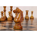Hand-carved antiqued boxwood knight chess piece showcased on a wooden chess board.