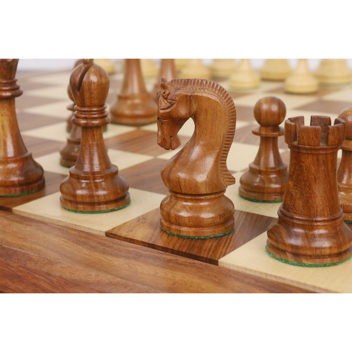 Golden Rosewood Leningrad Staunton knight standing on a wooden chess board.