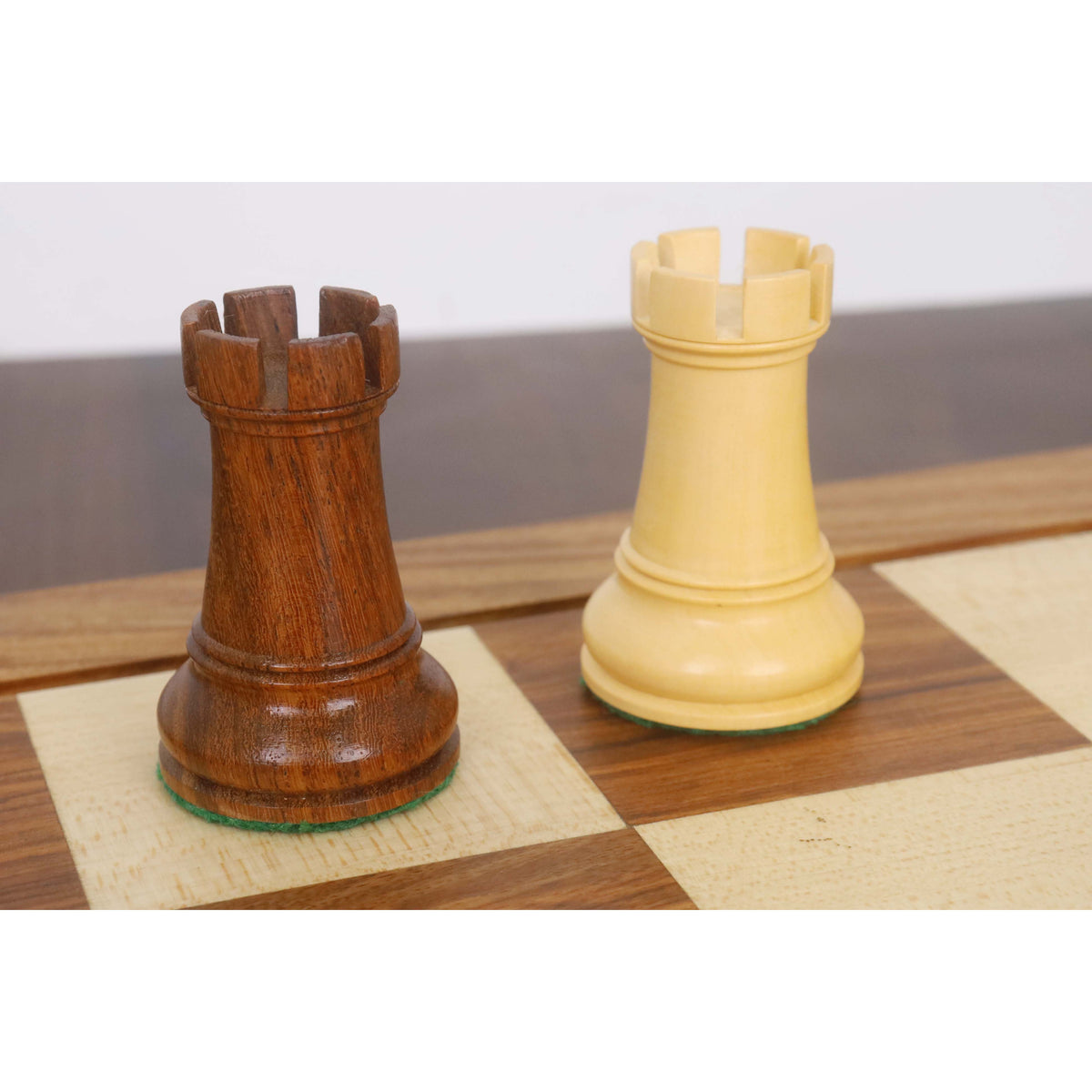 Side-by-side view of a Golden Rosewood and a boxwood rook from the Leningrad Staunton set.