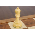 Elegant light Staunton bishop chess piece displayed on a wooden chessboard.