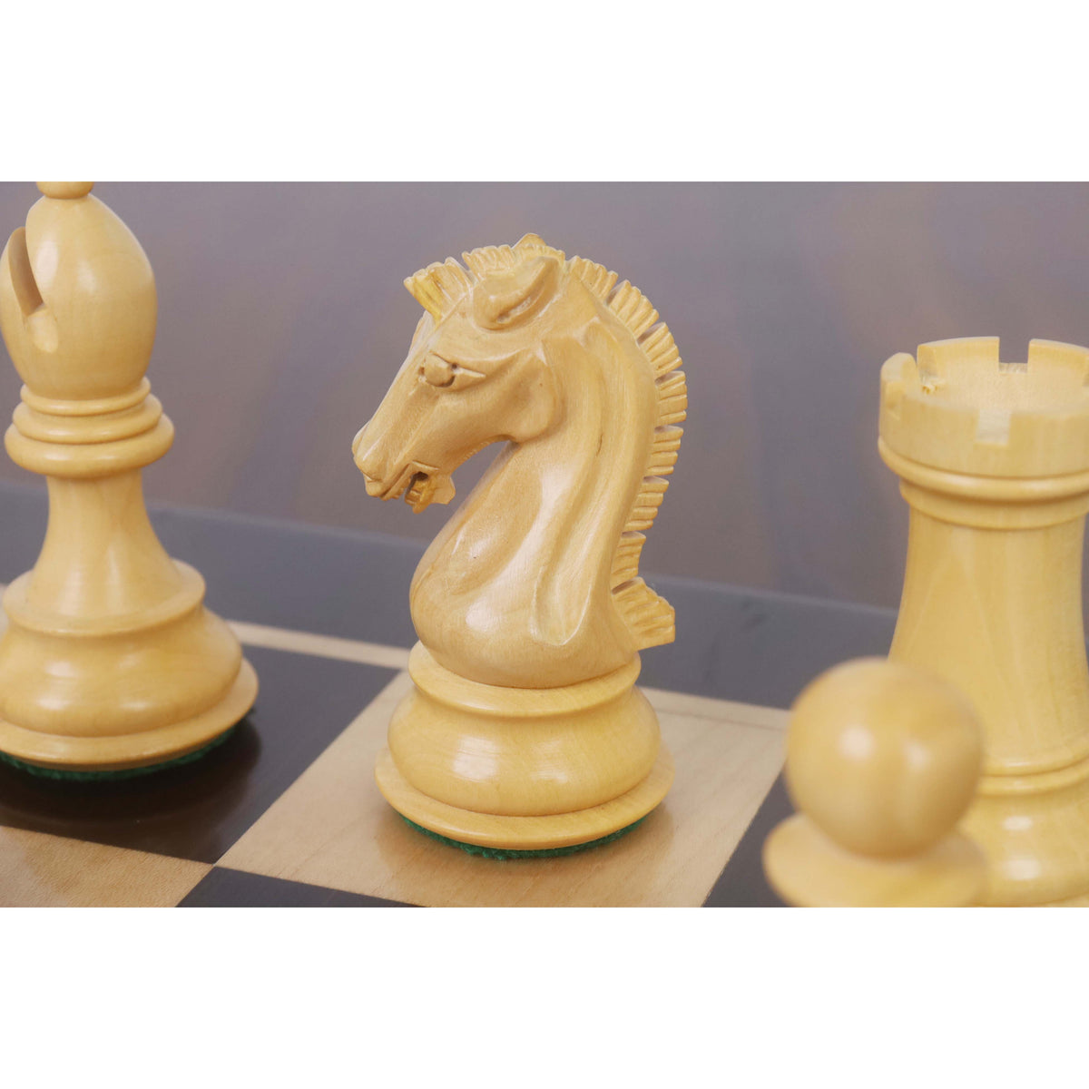 Close-up of a premium boxwood knight chess piece on a wooden board.
