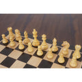 Ivory boxwood Staunton chess pieces set up on a wooden chessboard.