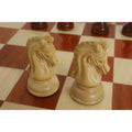 Close-up of handcrafted natural boxwood knight chess pieces on a board.