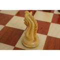 Side profile of a carved boxwood knight chess piece highlighting mane detail.