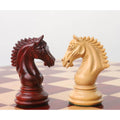 Close-up of two Staunton chess knights facing off on a luxury chessboard.