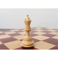 Light Boxwood Staunton bishop standing on a wooden chessboard.