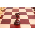 Single Bud Rosewood Rook chess piece on a wooden board.