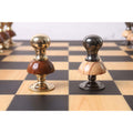 Close-up of the metallic gold and grey Pawns from the Victorian Fusion brass metal luxury chess set on a wooden board.