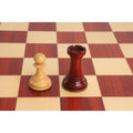Boxwood pawn and bud rosewood rook positioned on a wooden chessboard.